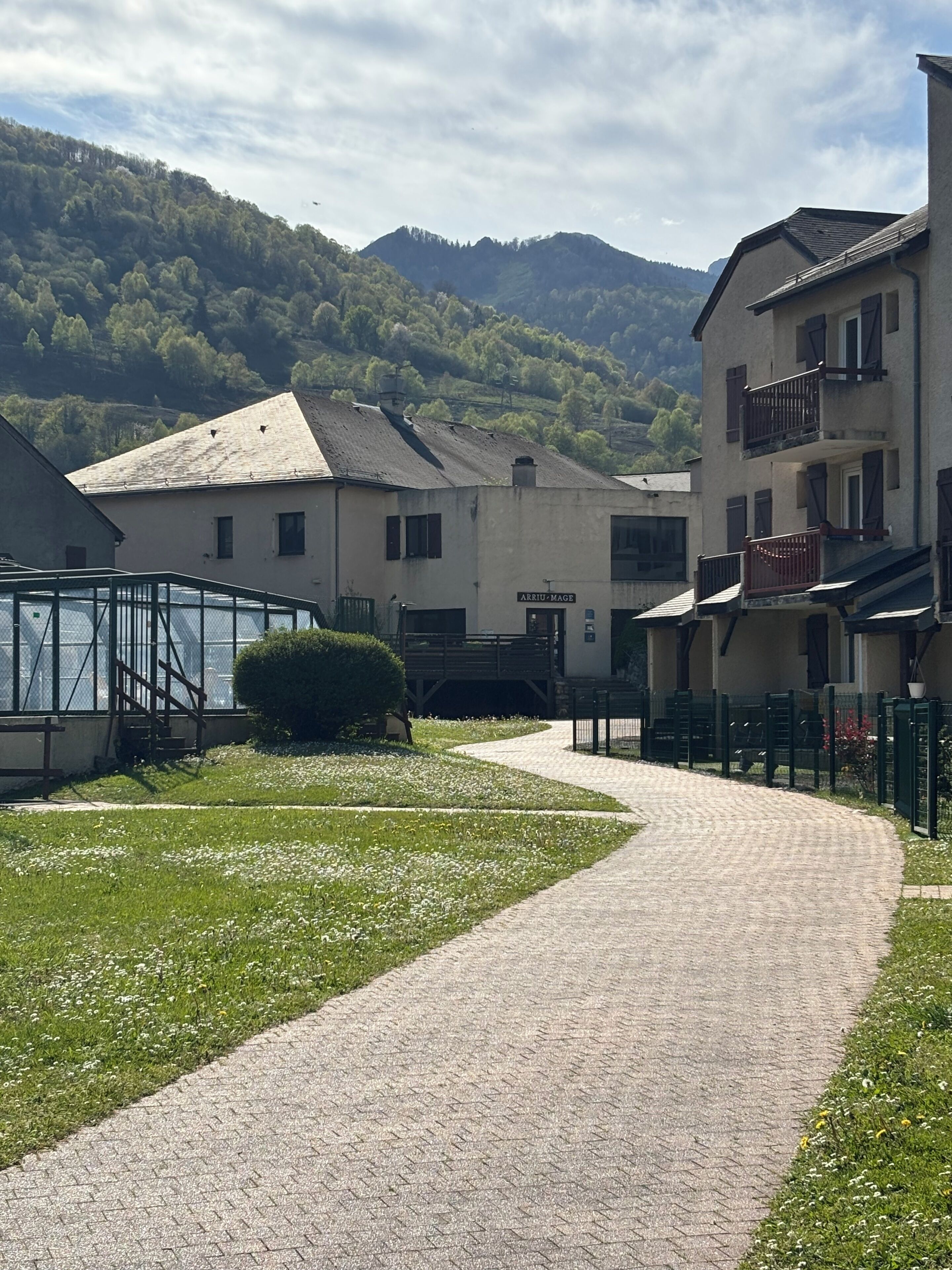 A paved pathway leading to a building with a sign reading 'ARRIVAZIONE MAGE.'