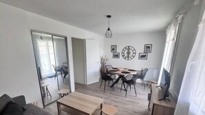 Ein modernes Wohnzimmer mit einer Couch, einem Couchtisch und einem Essbereich mit Stühlen und einem Tisch.