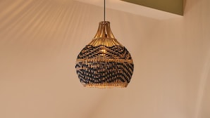 A dining area with a round table, black chairs, and a hanging light fixture. - Grain Loft - Luxury Cottages (Caersws)