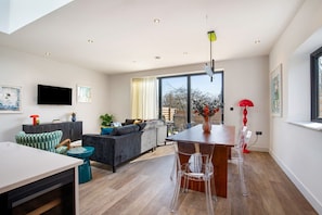 Una sala moderna con un sofá, una mesa de comedor y un televisor.