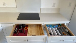 A kitchen with a black countertop, wooden drawer, and a white cabinet with multiple compartments. - Puppy play pen 2-bedroom house with AC in sunny Phoenix (Phoenix)