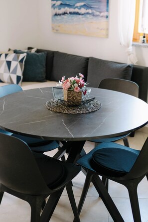Ein runder Esstisch mit Blumenarrangements in der Mitte, umgeben von Stühlen.