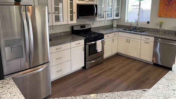 A modern kitchen with stainless steel appliances, white cabinetry, and a granite countertop. - 3-bedroom house in pleasant Phoenix with Pool AC and comfort (Phoenix)