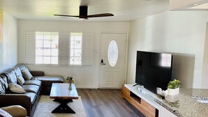 A living room with a sofa, coffee table, TV, and a ceiling fan. - 3-bedroom house in pleasant Phoenix with Pool AC and comfort (Phoenix)