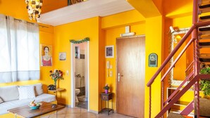 A living room with a sofa, a coffee table, and a staircase. - Cleo Apartment - Quaint Loft in Kefalonia (Kefalonia)