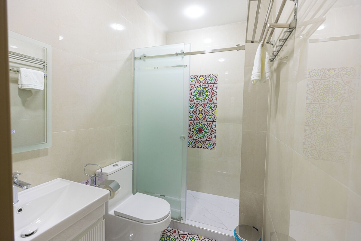 Un bagno con il water, lavandino e doccia.