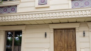 A building with a grand entrance, a staircase, and a large wooden door. - Boutique Hotel IMONA (Samarkand)