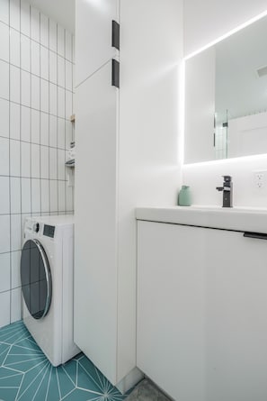 A modern bathroom with a washing machine, a sink, and a mirror. - Fully Equipped ADU Close to Business Centers, Hospital Centers, & Attractions (Los Angeles)