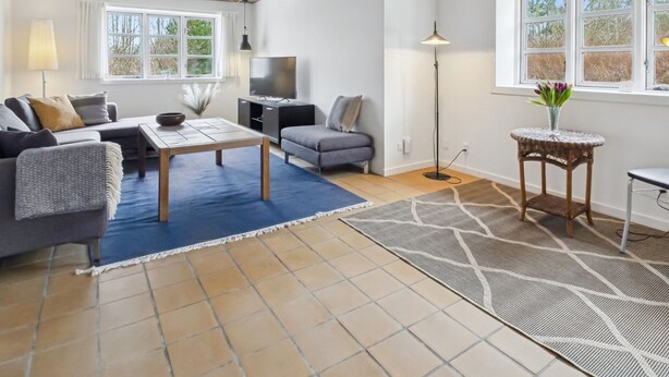 Un salon moderne comprenant un canapé, une table basse, un téléviseur et une petite table d’appoint.