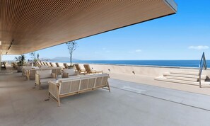 A beachside lounge with outdoor seating and a view of the ocean. - Oceanview 2BR Near Beach + Golden Zone Rooftop (Bucerías)