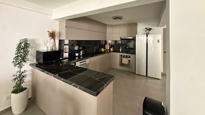 Una cucina moderna con isola centrale, forno a incasso e frigorifero.