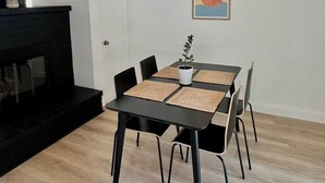A dining area with a table, chairs, a fireplace, and a ceiling light fixture. - Napa Home 10 Minutes from BottleRock & Downtown (Napa)