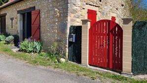 A stone building with a red gate, a mailbox, and a number '20' sign. - Charming gîte near Gourdon - stone, nature, enclosed garden, terrace (Concorès)