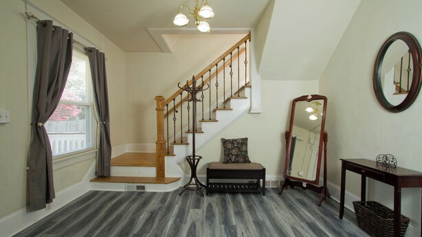 A staircase with wooden steps and a handrail, a bench with a cushion, a mirror on the wall, and a basket on the floor. - Welcome to the Blue Oasis! Come stay with us in our fully furnished 4-bedroom (Roanoke)