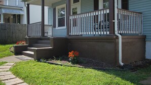 A residential house with a front porch, steps, and a small garden with flowers. - Welcome to the Blue Oasis! Come stay with us in our fully furnished 4-bedroom (Roanoke)