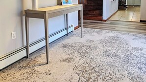 A modern interior with a staircase, a white console table, and a large mirror. - The off Main beach retreat! a spacious and cozy 6 bedroom home. (South Kingstown)