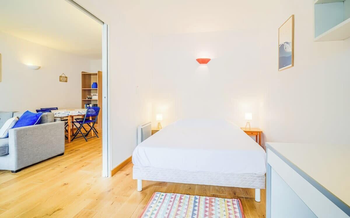 A bedroom with a bed, bedside tables, a desk, and a chair.