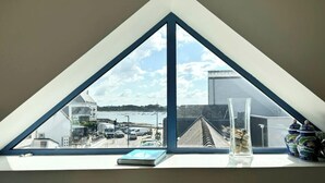 Ein dreieckiges Fenster mit Blick auf einen Parkplatz und Gebäude.