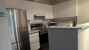 Een moderne keuken met roestvrijstalen apparatuur, witte kasten en een ingebouwde oven.