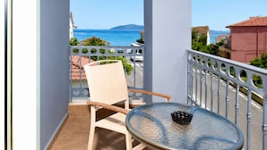 A balcony with a view of the sea, a chair, a table, and a railing. - Oeve Apartment - A Colourful Loft in Kefalonia (Kefalonia)