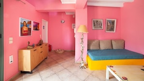 A pink room with a bed, a wooden dresser, and a lamp. - Oeve Apartment - A Colourful Loft in Kefalonia (Kefalonia)