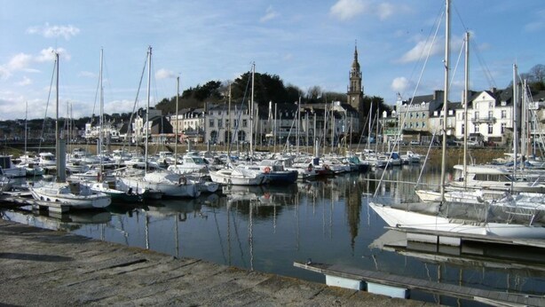 A marina with numerous boats docked, a prominent clock tower in the background, and buildings along the waterfront. - Ker Monette - PORDIC (PORDIC)