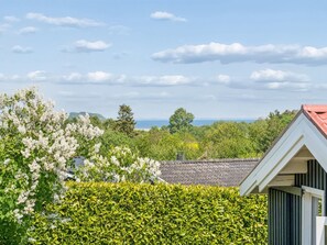 Ein Wohngebiet mit einem Haus, üppigem Grün und Blick auf das Meer.