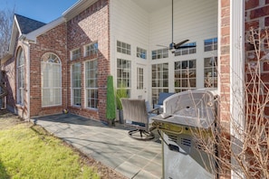 A brick house with a covered patio, a grill, and a large window. - Pleasant 4-bedroom house with AC in charming Richardson (Richardson)