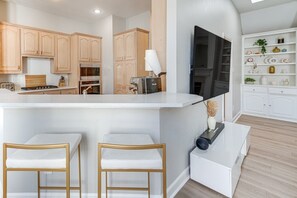 A modern kitchen with wooden cabinets, a Breville stove, and a white countertop. - Pleasant 4-bedroom house with AC in charming Richardson (Richardson)
