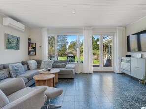Una sala de estar moderna con sofá, mesa de centro y televisor.