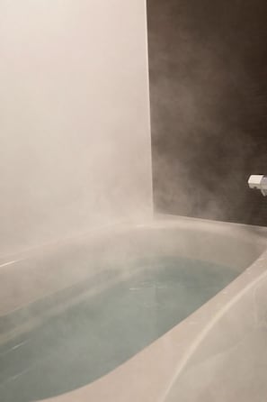 Eine Badewanne mit aufsteigendem Dampf, der ein wohlig warmes Bad anzeigt.