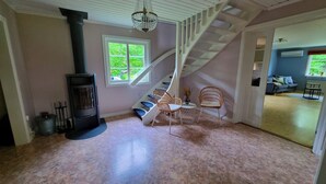 A living room with a fireplace, a staircase, and a view of the outdoors. - Family House Near Tiveden National Park with fireplace, piano, big property (Finnerödj)
