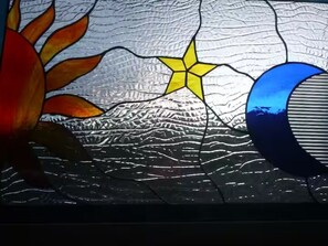 A stained glass window with a mountain, a star, and a crescent moon. - Two houses for the price of one at beautiful orchid farm. (Pāhoa)