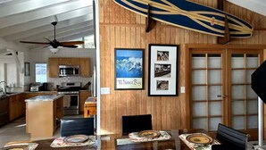 Ein Essbereich mit Holzwand, einem Surfbrett und gerahmten Bildern.