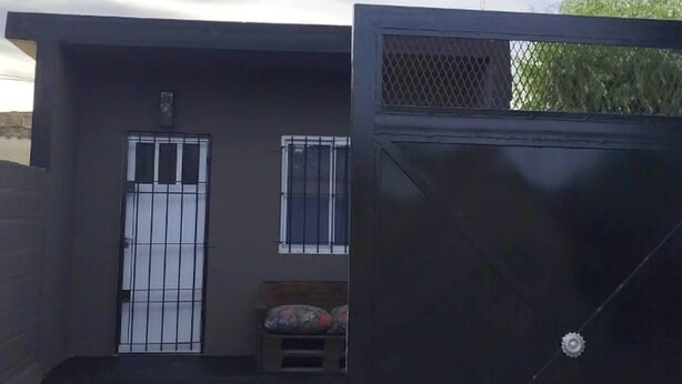 A building with a gated entrance, a small porch area, and a window with barred security. - Studio Apartment, Special Winter (Santa Teresita)