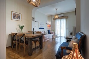 Ein großzügiger Wohnbereich mit Esstisch, Stühlen, einer Couch und einer Lampe.
