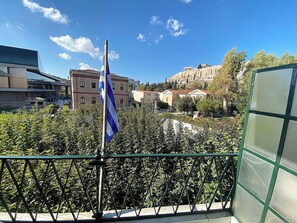 Ein Balkon mit Blick auf eine Flagge, ein Gebäude und einen Berg im Hintergrund.