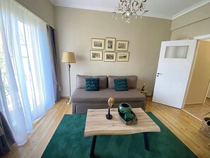 Ein Wohnzimmer mit einer Couch, einem Couchtisch, einer Lampe und gerahmten Bildern an der Wand.