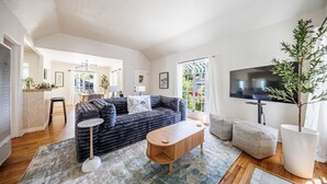Ein Wohnzimmer mit einer Couch, einem Couchtisch und einem Fernseher.