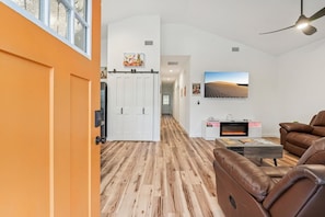 Ein modernes Wohnzimmer mit Kamin, Ledersofa und Holzboden.