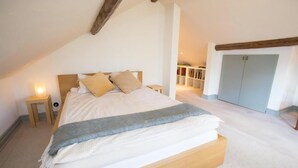 A bedroom with a large bed, a bedside table, a nightstand, and a wardrobe. - French countryhouse atmosphere (Vessigebro)