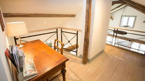 A wooden dining table with a lamp, a chair, and a view of a balcony with a railing. - French countryhouse atmosphere (Vessigebro)