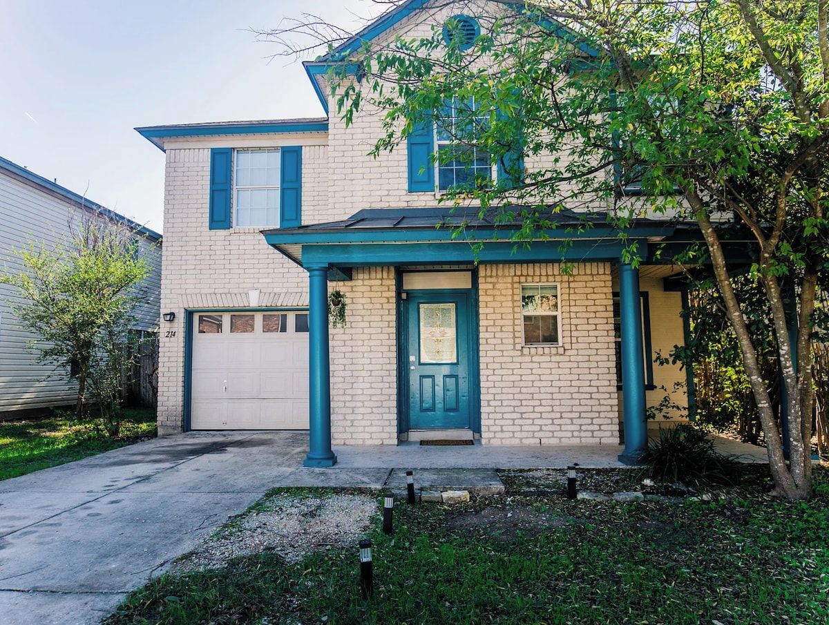 A two-story house with a garage, a front porch, and a small front yard.