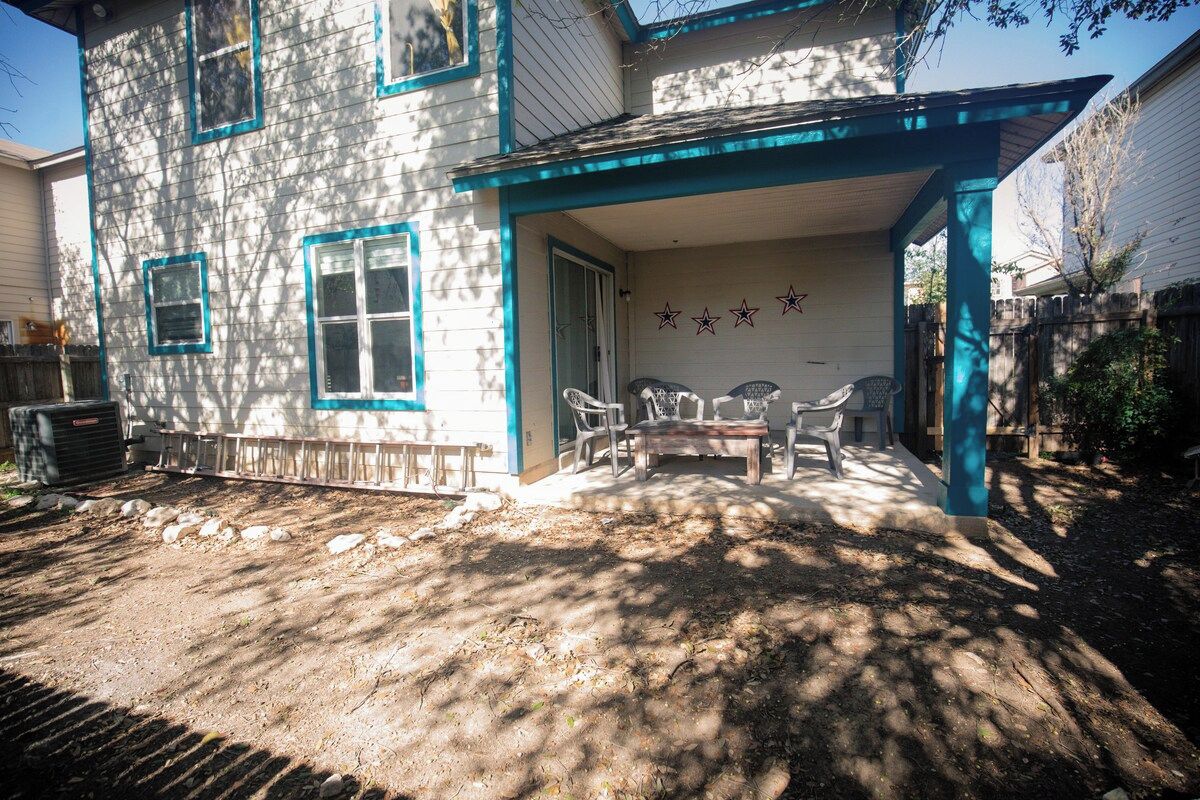 A two-story house with a covered patio area.