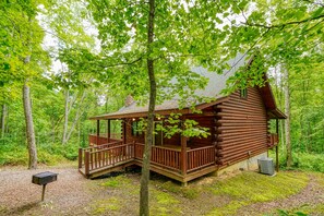 Una baita di legno con veranda, immersa in una foresta.