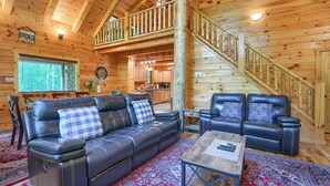A cabin interior with a wooden interior, a sofa, a chair, a table, and a staircase. - Memory Ridge Retreat, Sleeps 8, Walking Distance to Old Man's Cave (Logan)