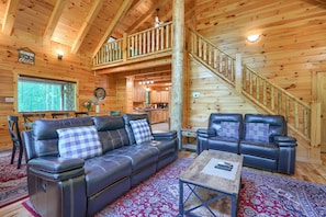 A cabin interior with a wooden interior, a sofa, a chair, a table, and a staircase. - Memory Ridge Retreat, Sleeps 8, Walking Distance to Old Man's Cave (Logan)