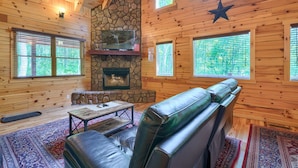 A log cabin interior with a stone fireplace, leather seating, and large windows. - Memory Ridge Retreat, Sleeps 8, Walking Distance to Old Man's Cave (Logan)