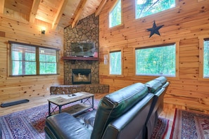 A log cabin interior with a stone fireplace, leather seating, and large windows. - Memory Ridge Retreat, Sleeps 8, Walking Distance to Old Man's Cave (Logan)