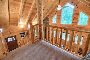 A wooden interior with a staircase, wooden beams, and multiple windows. - Memory Ridge, Walk to Old Man (Logan)